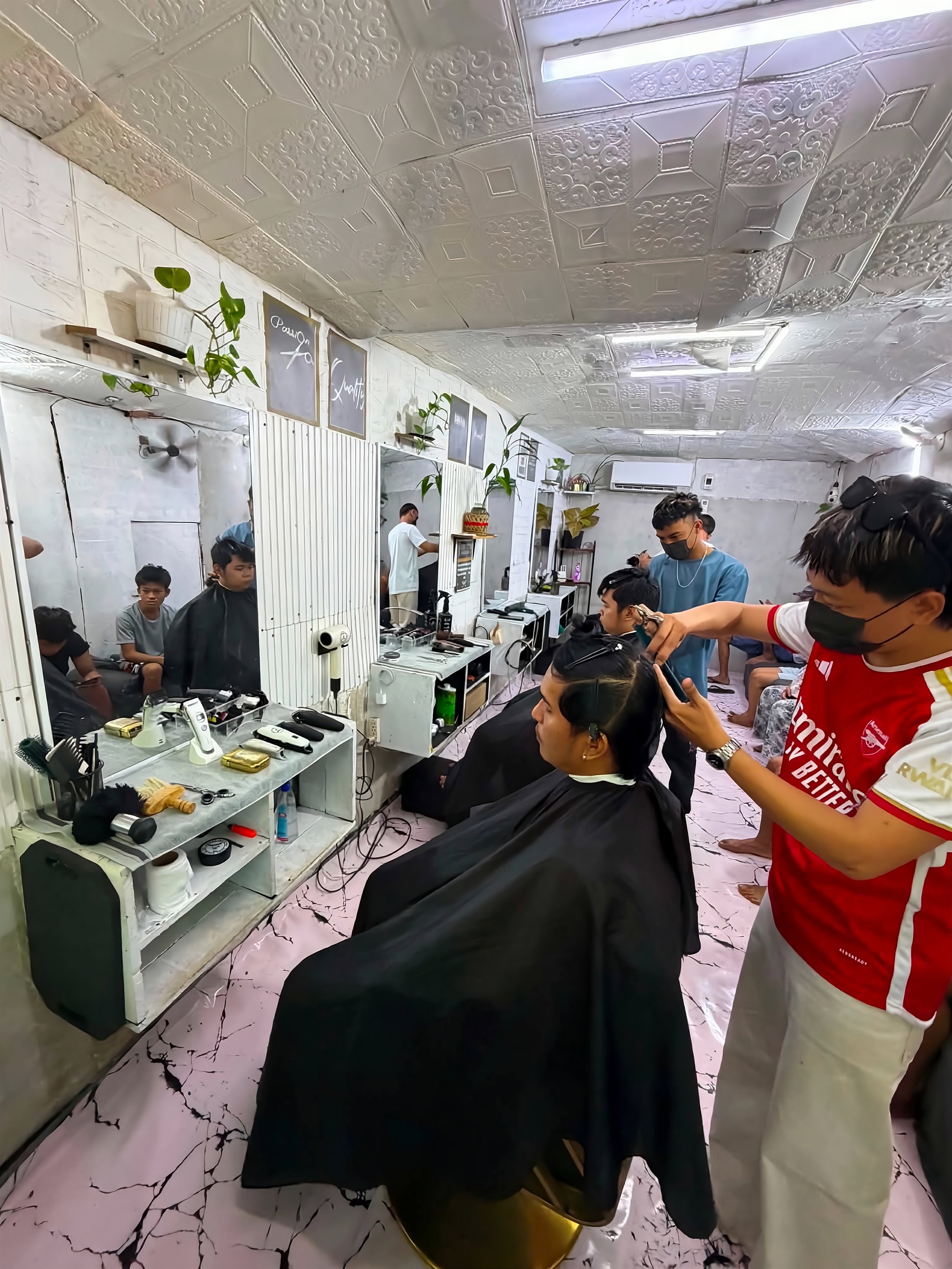 Inside Cool Cuts Barbershop - a barber giving a customer a haircut